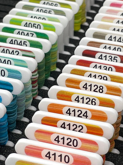 White acrylic cross stitch storage bobbin with printed DMC swatch by Pip and Chip