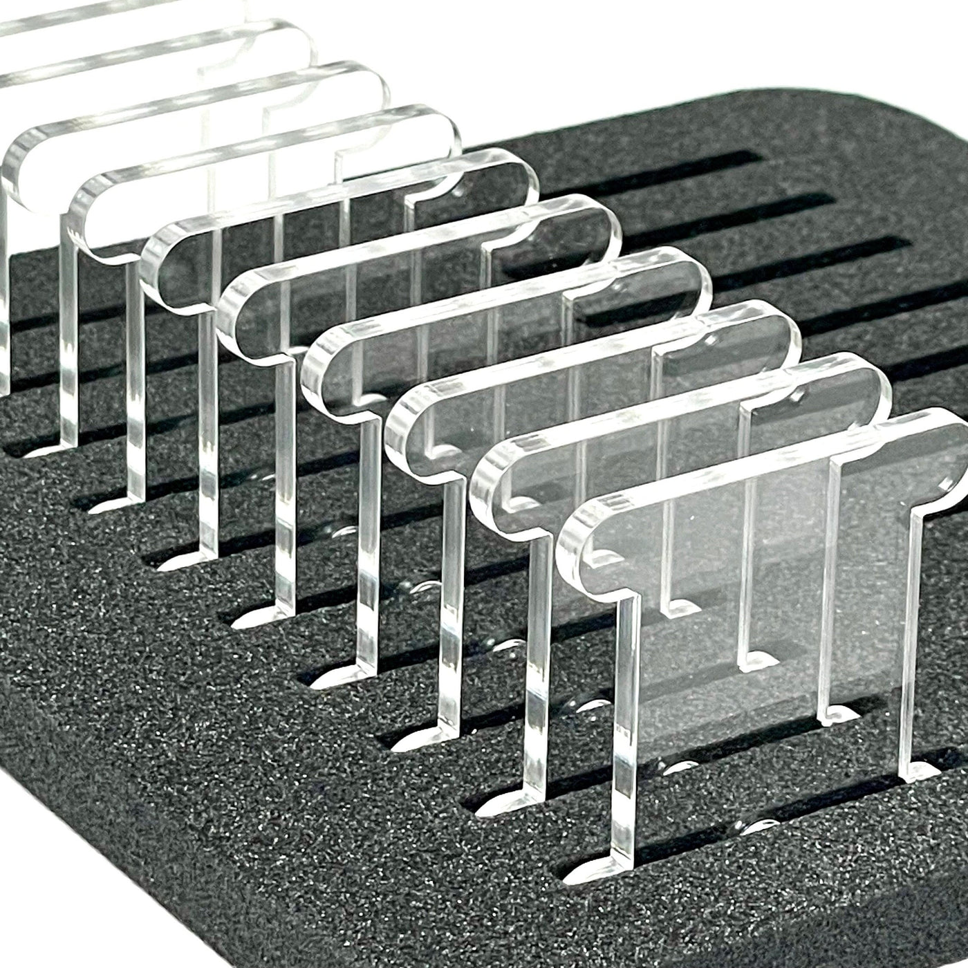Set of clear acrylic floss storage bobbins stood upright in foam insert by Pip and Chip